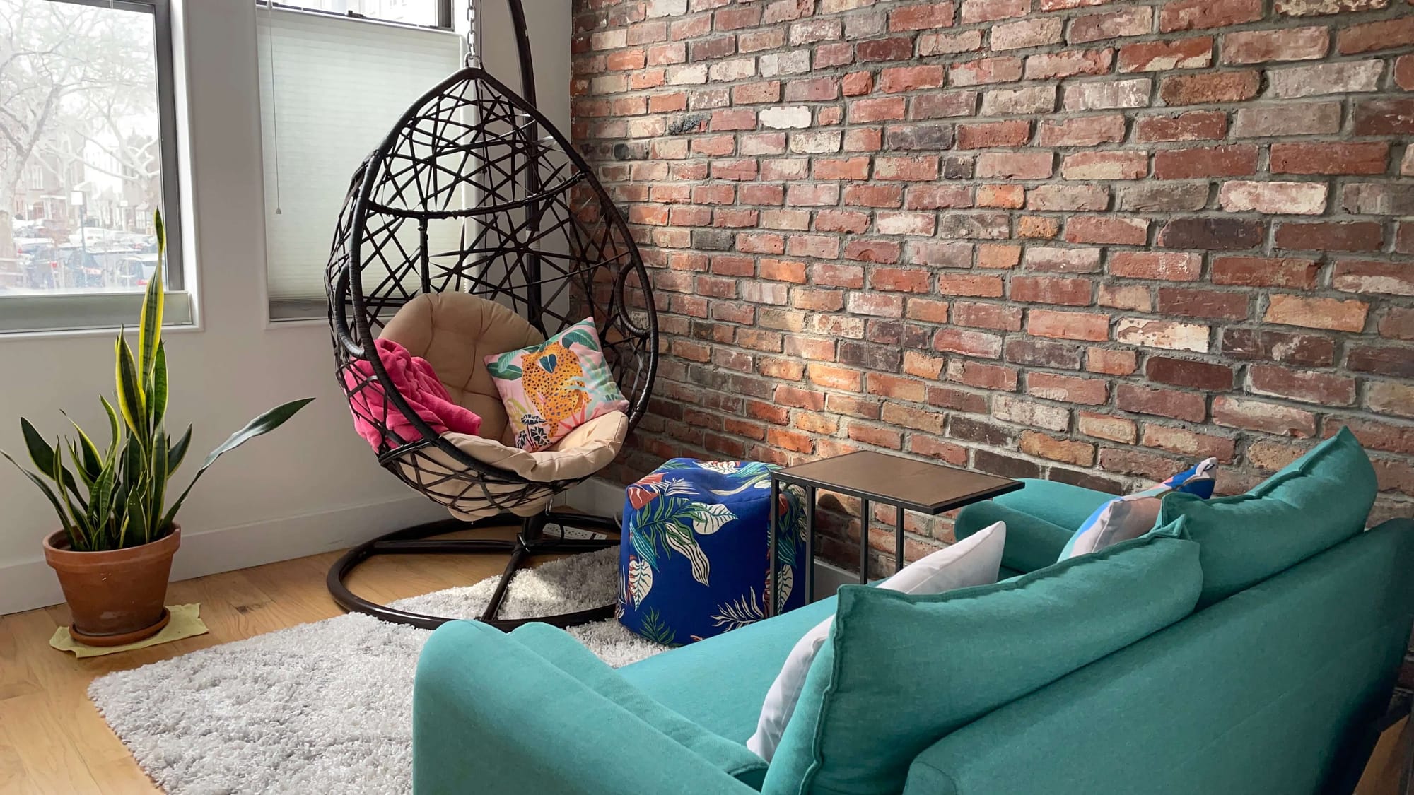 A colorful living room furniture set against a Brooklyn brick wall.