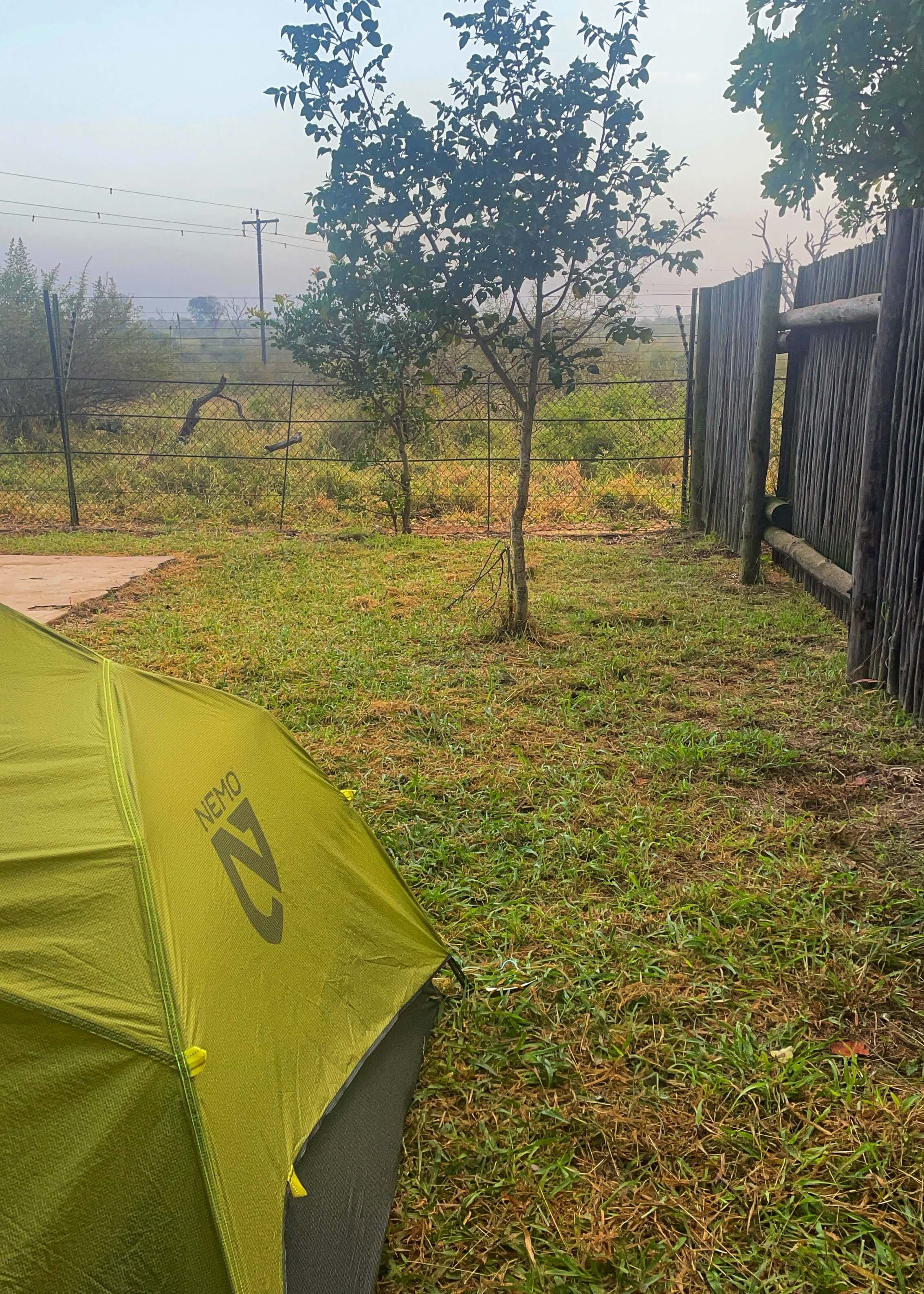 A green tent is pictured, with a fence in front of it.
