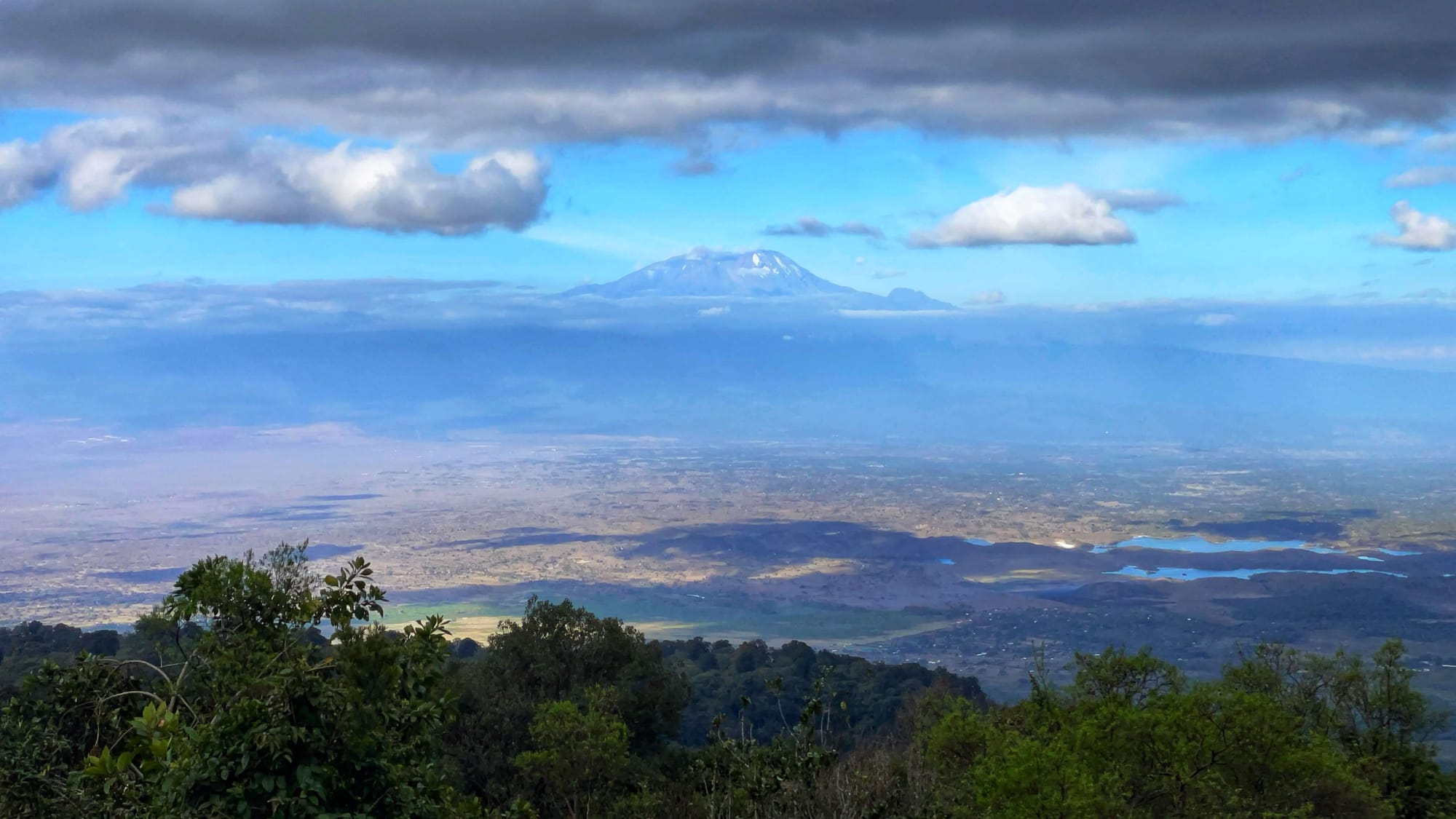 A huge mountain rises up from the valley on a cloudy day.