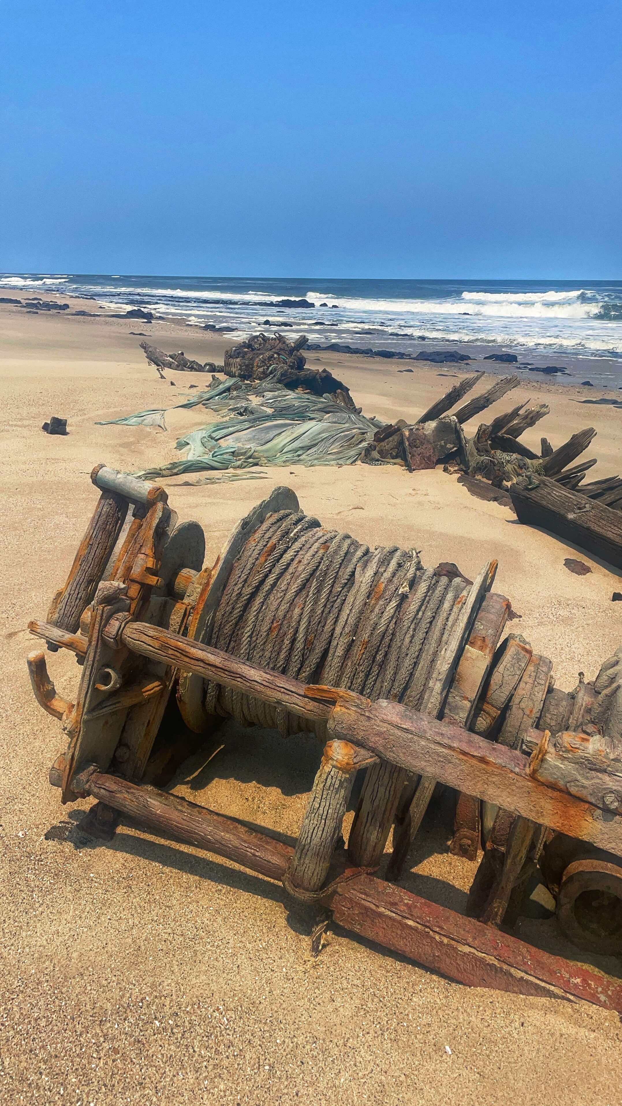 Wound rope and other wooden ship wreckage along the coastline.