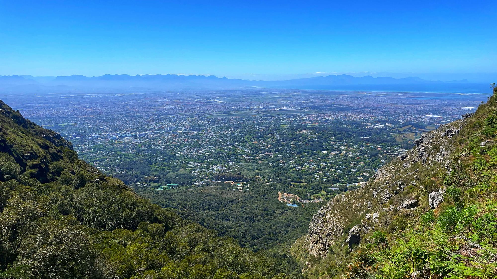 From high up on a mountain, a big city can be seen down below. 