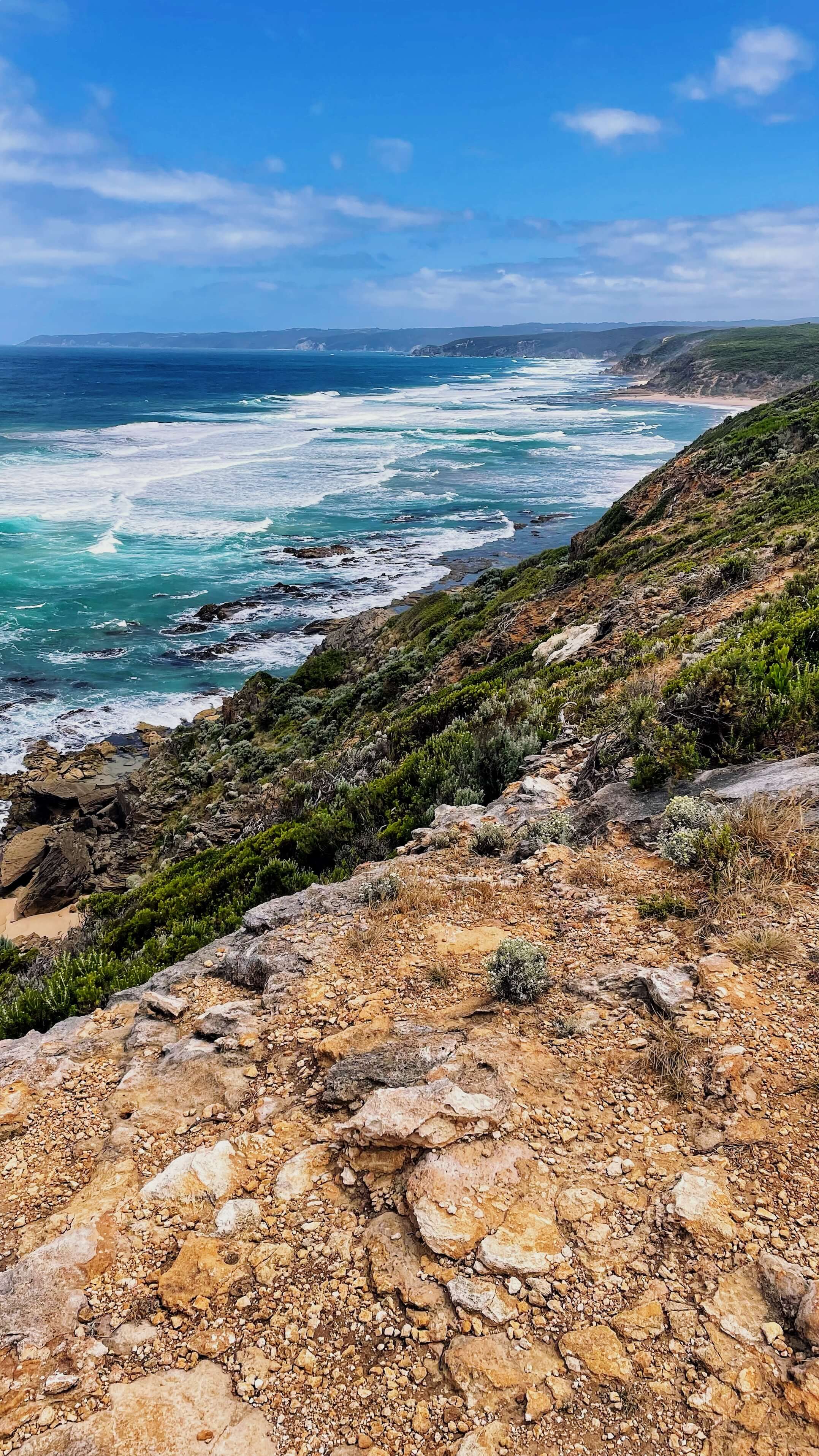 A long cliff above the blue ocean stretches far into the distance.
