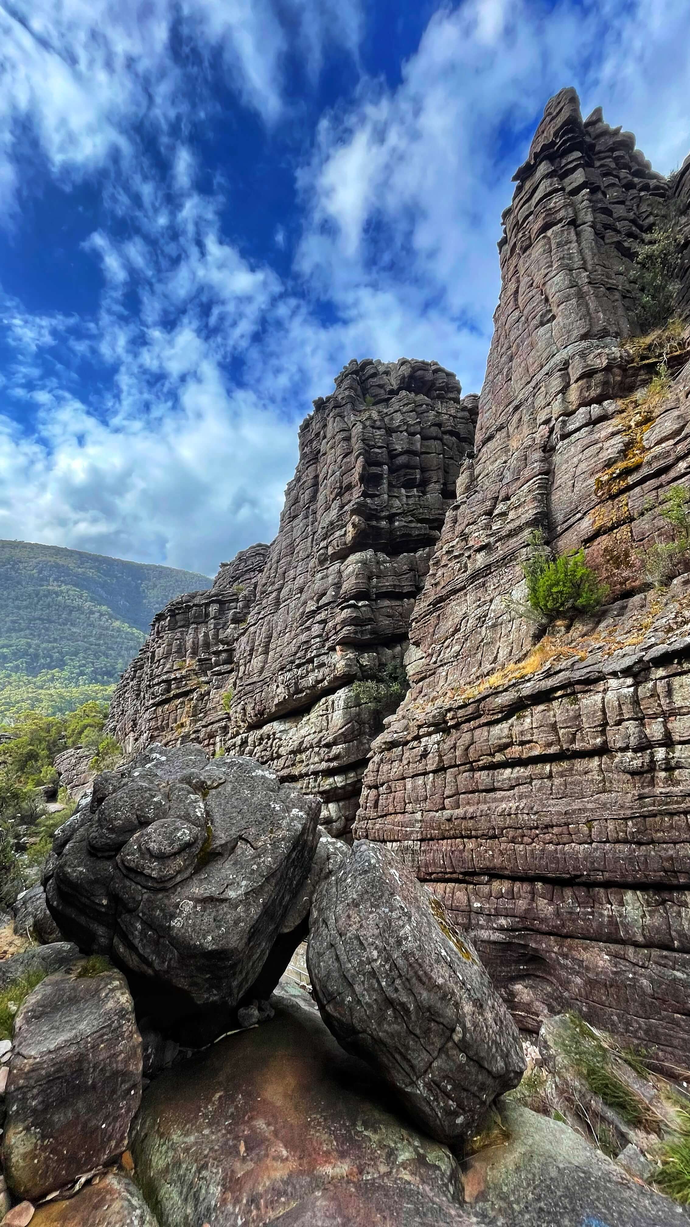 Tall chimney like rock formations made of sandstone, with layers and cracks like bricks.
