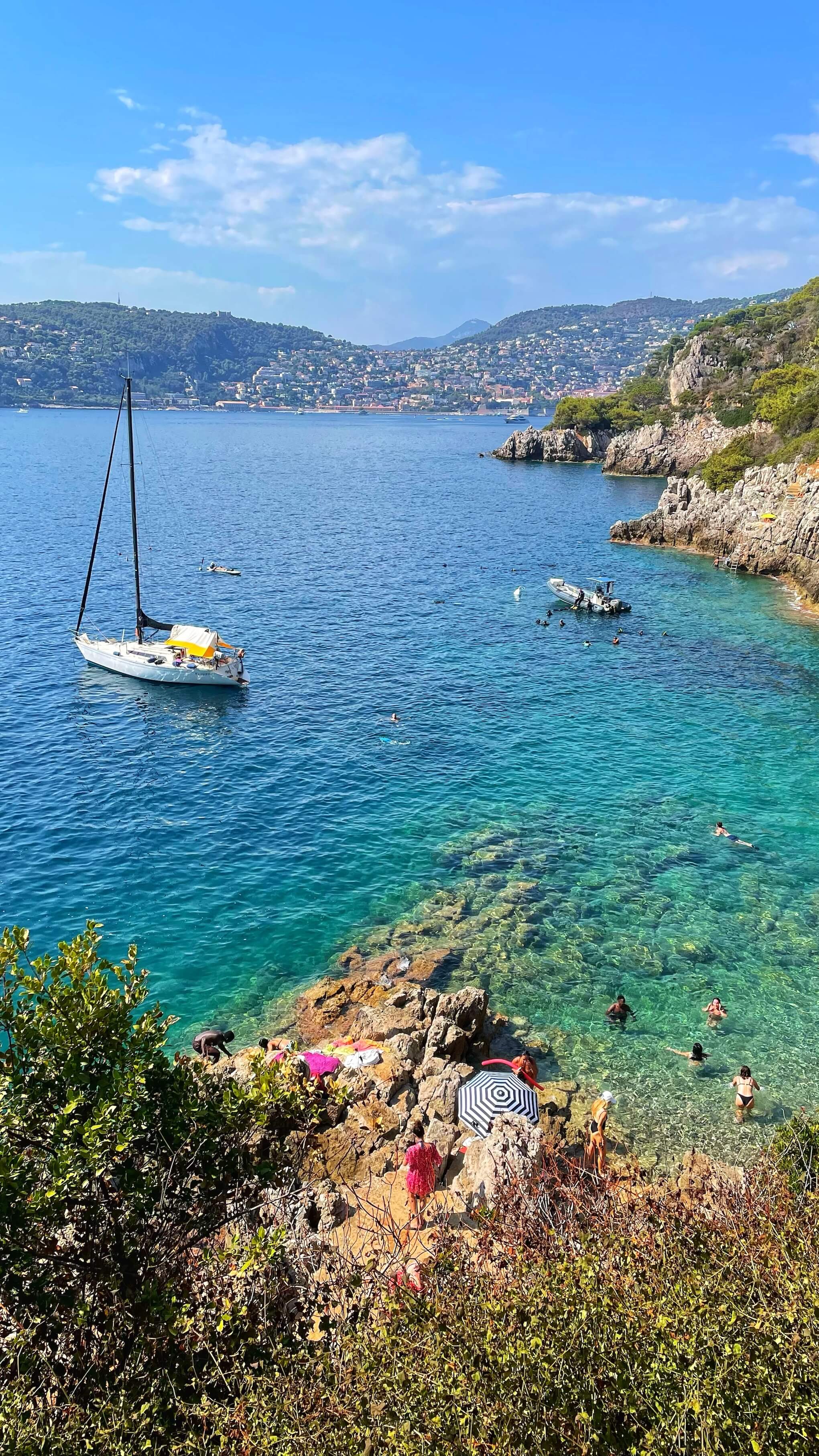 People pitch towels and umbrellas along the rocks of Pointe Cau de Nao on Cap Ferrat.