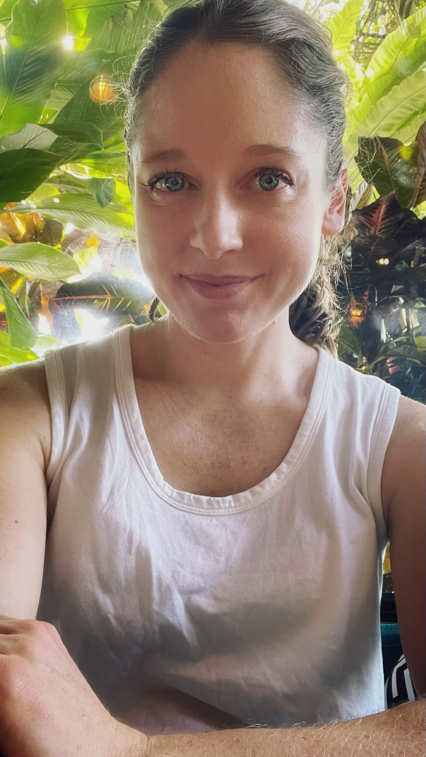 Clara Ritger smiles with tropical plants behind her.