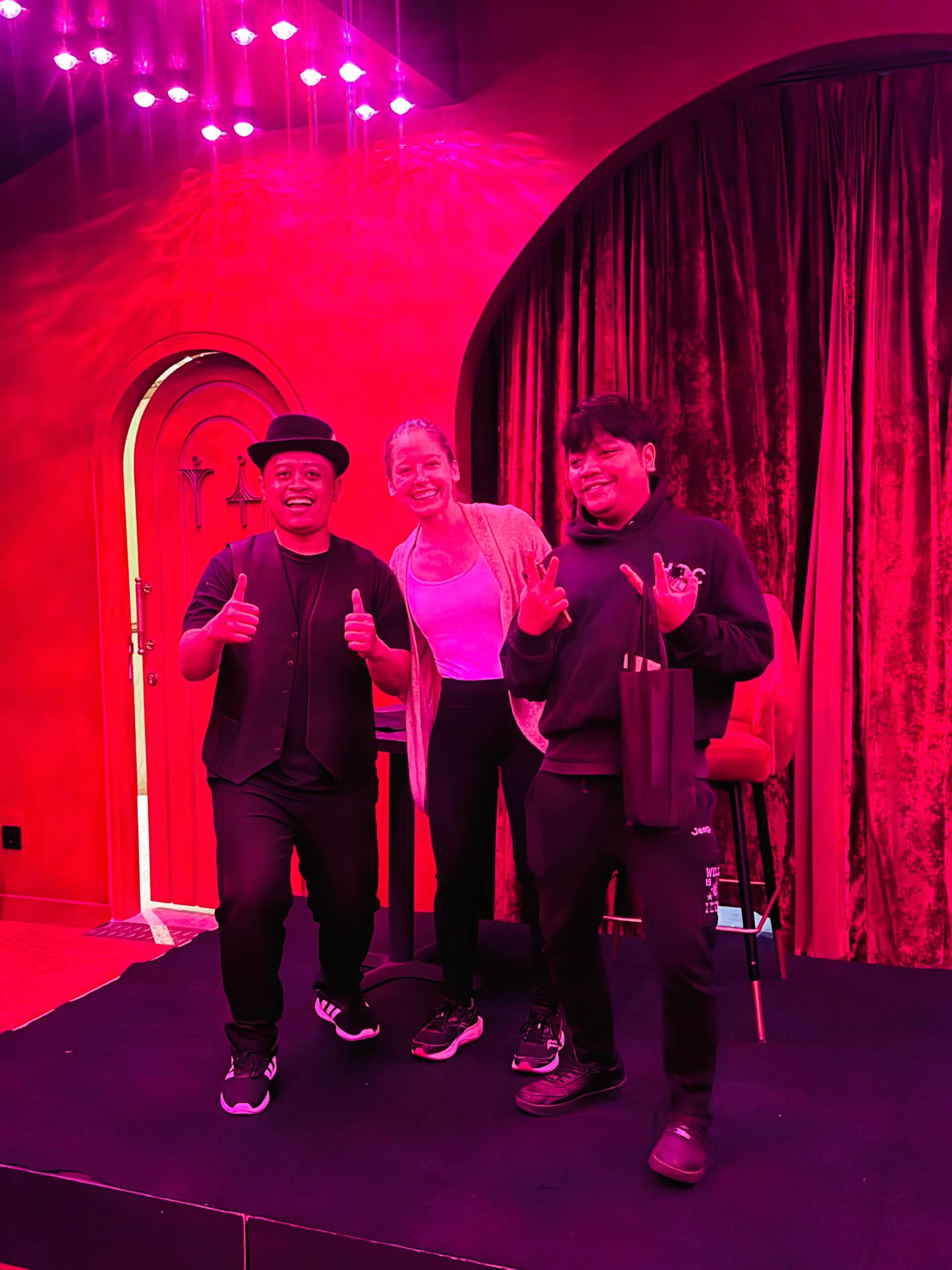 Clara Ritger and two Indonesian comedy magicians posing for a photo on stage.