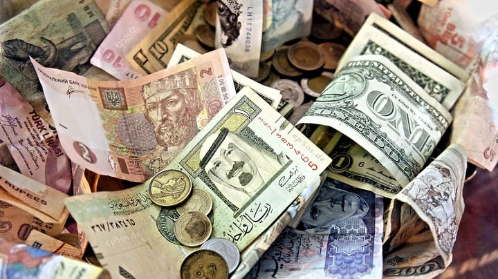 A pile of bills and coins in a mix of currencies.