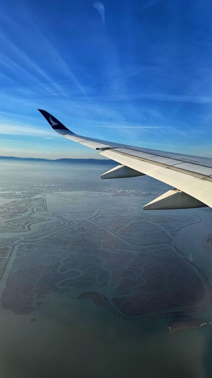 An airplane wing over the water.