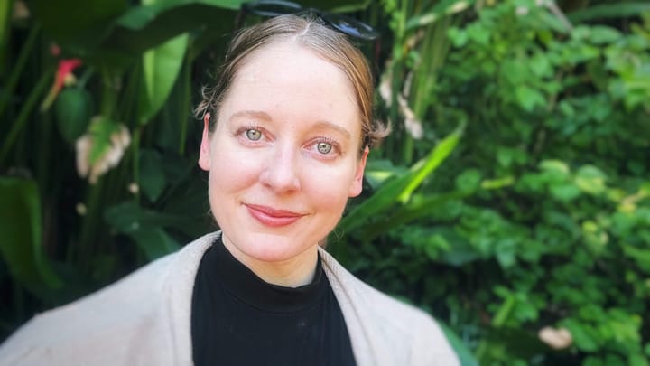 The author, Clara Ritger, in a garden, looking a the camera with a peaceful expression.